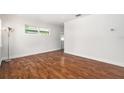 Bright living room with beautiful hardwood floors and natural light from the window at 4421 W Iowa Ave, Tampa, FL 33616
