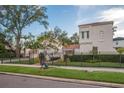 Charming home features a black metal fence, mature landscaping, and a lovely stucco exterior, offering curb appeal at 54 Aegean Ave, Tampa, FL 33606