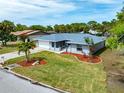 An aerial view of a home with a well-manicured lawn, a two-car garage, and a landscaped yard at 5471 Nimitz Rd, New Port Richey, FL 34652