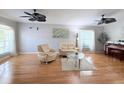 Spacious living room showcasing wood floors, neutral paint, ceiling fans and comfortable seating at 5702 War Admiral Dr, Wesley Chapel, FL 33544