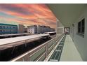 Community building balconies with parking, view of nearby buildings and a colorful sunset sky at 5935 30Th S Ave # 204, Gulfport, FL 33707