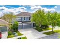 Two-story home with a three-car garage, lush landscaping, and a spacious driveway at 6423 Seasound Dr, Apollo Beach, FL 33572