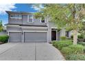 Classic two-story home with a three-car garage, neutral color scheme, and a welcoming entrance at 6423 Seasound Dr, Apollo Beach, FL 33572