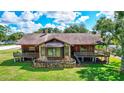 Exterior shot of home featuring stone accents, a bay window, and a surrounding green lawn at 6501 62Nd N St, Pinellas Park, FL 33781