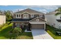 Beautiful two-story home with lush lawn, mature landscaping, and an attached two-car garage at 7653 Stoney Hill Dr, Wesley Chapel, FL 33545