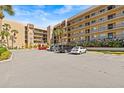 Exterior view of the condo building and its parking lot with multiple cars parked on a sunny day at 90 S Highland Ave # 1317, Tarpon Springs, FL 34689