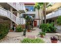 Inviting courtyard with lush plants, white stairs, and red accents at 1012 Pearce Dr # 105, Clearwater, FL 33764