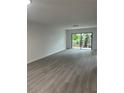 Bright living room with wood-look flooring and sliding glass doors to the outdoors at 10216 N Pawnee Ave, Tampa, FL 33617