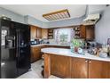 Functional kitchen with wooden cabinets, a center island, and modern black appliances at 1407 Overlea St, Clearwater, FL 33755
