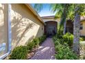 Pathway leading to the front porch surrounded by lush greenery and colorful plants at 16106 Amethyst Key Dr, Wimauma, FL 33598