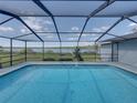 Screened-in pool area with beautiful lake views, perfect for outdoor enjoyment at 18253 Townsend House Rd, Dade City, FL 33523