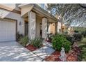 Inviting front porch with decorative columns, a small side garden, and a view of neighboring houses at 20220 Autumn Fern Ave, Tampa, FL 33647