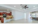 Spacious living area with tile flooring, ceiling fan, and an open flow to the sun room and kitchen at 2234 Nottingham Greens Dr # 2234, Sun City Center, FL 33573