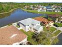 A birds eye view of a suburban home surrounded by a pond, with lush landscaping at 25631 Bruford Blvd, Land O Lakes, FL 34639