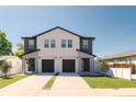 Modern townhome featuring a black roof, gray accents, and individual driveways with manicured lawn at 2608 W Saint Joseph St # 2, Tampa, FL 33607