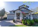 Charming two-story home with covered porch, rocking chairs, neatly manicured landscaping, and American flag at 2671 Murray Pass, Odessa, FL 33556
