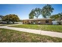 Charming single-story home with mature trees, and a green lawn at 2707 Morningside Dr, Clearwater, FL 33759