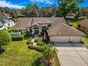 Expansive home featuring a well-manicured lawn, lush landscaping, and a three-car garage, blending luxury with curb appeal at 2806 Forest Club Dr, Plant City, FL 33566