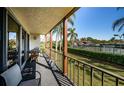 Relaxing balcony with outdoor seating overlooking a vibrant green landscape and nearby tennis courts at 3021 Countryside Blvd # 26A, Clearwater, FL 33761