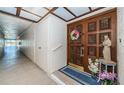 Inviting unit entrance featuring a wooden door with decorative carvings, a colorful wreath, and charming decor at 3021 Countryside Blvd # 26A, Clearwater, FL 33761