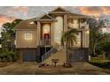 Inviting two-story home with a front-facing two-car garage, landscaped yard, and charming balcony at sunset at 3114 Bluff Blvd, Holiday, FL 34691