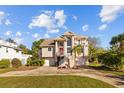 Inviting two-story home with a front-facing two-car garage, landscaped yard, and charming balcony at 3114 Bluff Blvd, Holiday, FL 34691