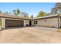 Bright home exterior with solar panels, a two-car garage, and stylish entrance with seating and updated landscaping at 35128 Excalibur Rd, Webster, FL 33597