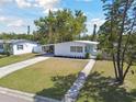 A charming single story home with a well-manicured lawn, complemented by mature trees and a welcoming driveway at 4030 Marlin Se Dr, St Petersburg, FL 33705