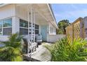 Cozy front porch features comfortable seating and lush tropical landscaping, creating a welcoming entrance at 4030 Marlin Se Dr, St Petersburg, FL 33705