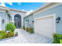 The entryway features a stylish archway, a paved walkway, and landscaping at 4926 Pamplona Ct, Wimauma, FL 33598