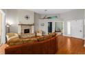Bright living room with a brick fireplace, hardwood floors, and an open layout perfect for entertaining at 5123 Whispering Leaf Trl, Valrico, FL 33596