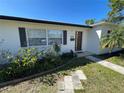 Inviting home exterior featuring a well-maintained lawn, a stone walkway, and beautiful front door at 6044 6Th N Ave, St Petersburg, FL 33710