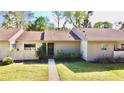 Well-maintained townhouse with a manicured lawn and garden beds, showing curb appeal at 610 S Woodlands Dr, Oldsmar, FL 34677