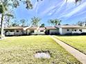 Exterior shot of the home featuring the walkway, lawn, and updated landscaping at 610 S Woodlands Dr, Oldsmar, FL 34677
