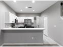 Modern kitchen with stainless steel appliances, white cabinetry, and a breakfast bar at 6709 Lake Rochester Ln, Gibsonton, FL 33534