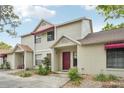 Charming townhome with a red front door, awning, and well-maintained landscaping at 8419 Laurelon Pl, Temple Terrace, FL 33637