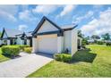 Beautiful home showcasing an attached garage, lush lawn, and manicured shrubbery at 908 Rosewood Ln, Palm Harbor, FL 34684