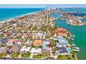 Stunning aerial view of a waterfront community with beautiful homes and boat access to the ocean at 115 16Th St, Belleair Beach, FL 33786
