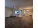 Open-concept living room featuring neutral carpet, light fixtures, and a view into the kitchen at 12760 Indian Rocks Rd # 540, Largo, FL 33774