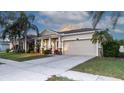 Charming home features a front porch, two-car garage, and well-maintained landscaping at 1705 Bonita Bluff Ct, Ruskin, FL 33570
