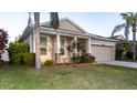 One-story home with a manicured front yard, covered porch, two-car garage, and palm trees at 1705 Bonita Bluff Ct, Ruskin, FL 33570