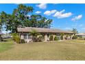 Attractive villa featuring manicured lawns, mature trees, and well-maintained landscaping at 1904 Canterbury Ln # 27, Sun City Center, FL 33573