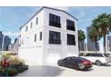 Modern home featuring black-framed windows, black railings, ample garage space, and a well manicured lawn at 2004 Gulf Blvd, Indian Rocks Beach, FL 33785