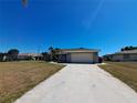 Single-story home with a spacious driveway, lush landscaping, and a well-maintained lawn at 26 Clintwood Ave, Englewood, FL 34223