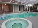 Screened-in pool and spa with tile trim, accessible from sliding glass doors at 26 Clintwood Ave, Englewood, FL 34223
