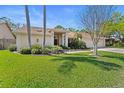 Inviting single-story home with manicured lawn, decorative landscaping, and a two car garage for ample parking at 3442 Beech Trl, Clearwater, FL 33761
