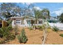 Charming single-story home with a turquoise door, manicured lawn, and privacy fence at 6327 Emerson S Ave, St Petersburg, FL 33707