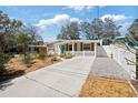 Charming single-story home featuring a manicured lawn, concrete driveway, and a delightful picket fence at 6327 Emerson S Ave, St Petersburg, FL 33707