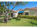 Beautiful home features a well-manicured lawn, red tile roof, and a blue awning over the entrance at 8805 41St N St, Pinellas Park, FL 33782