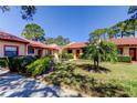 Beautiful home exterior with a well-maintained lawn, vibrant landscaping, and classic red tile roof at 9769 86Th Ave # 9769, Seminole, FL 33777
